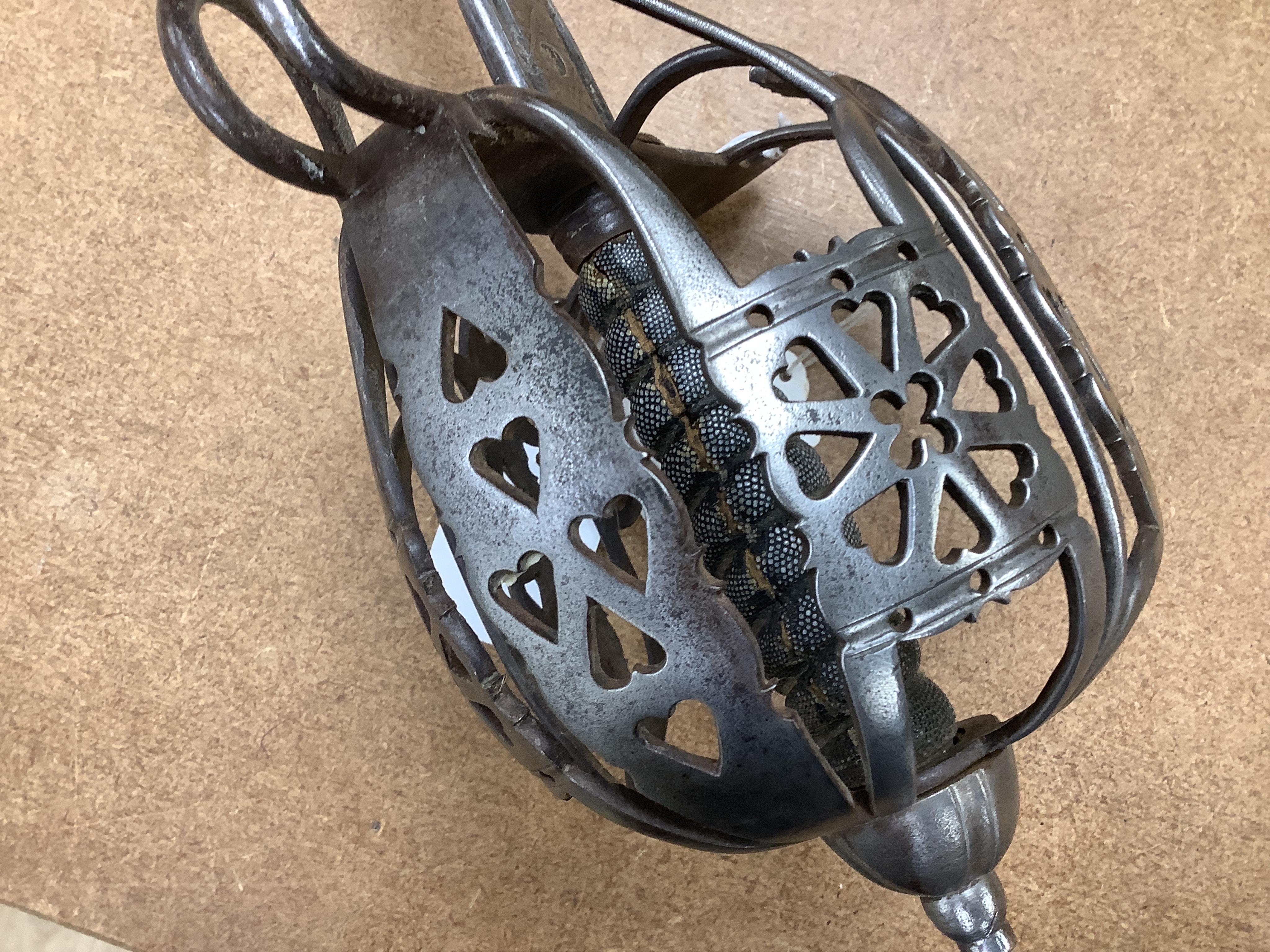 A late Victorian officer’s sword of the Black Watch, claymore blade etched with regimental title and VR cipher, regulation basket hilt, fish skin covered grip, in its leather covered field service scabbard, blade 82cm. C